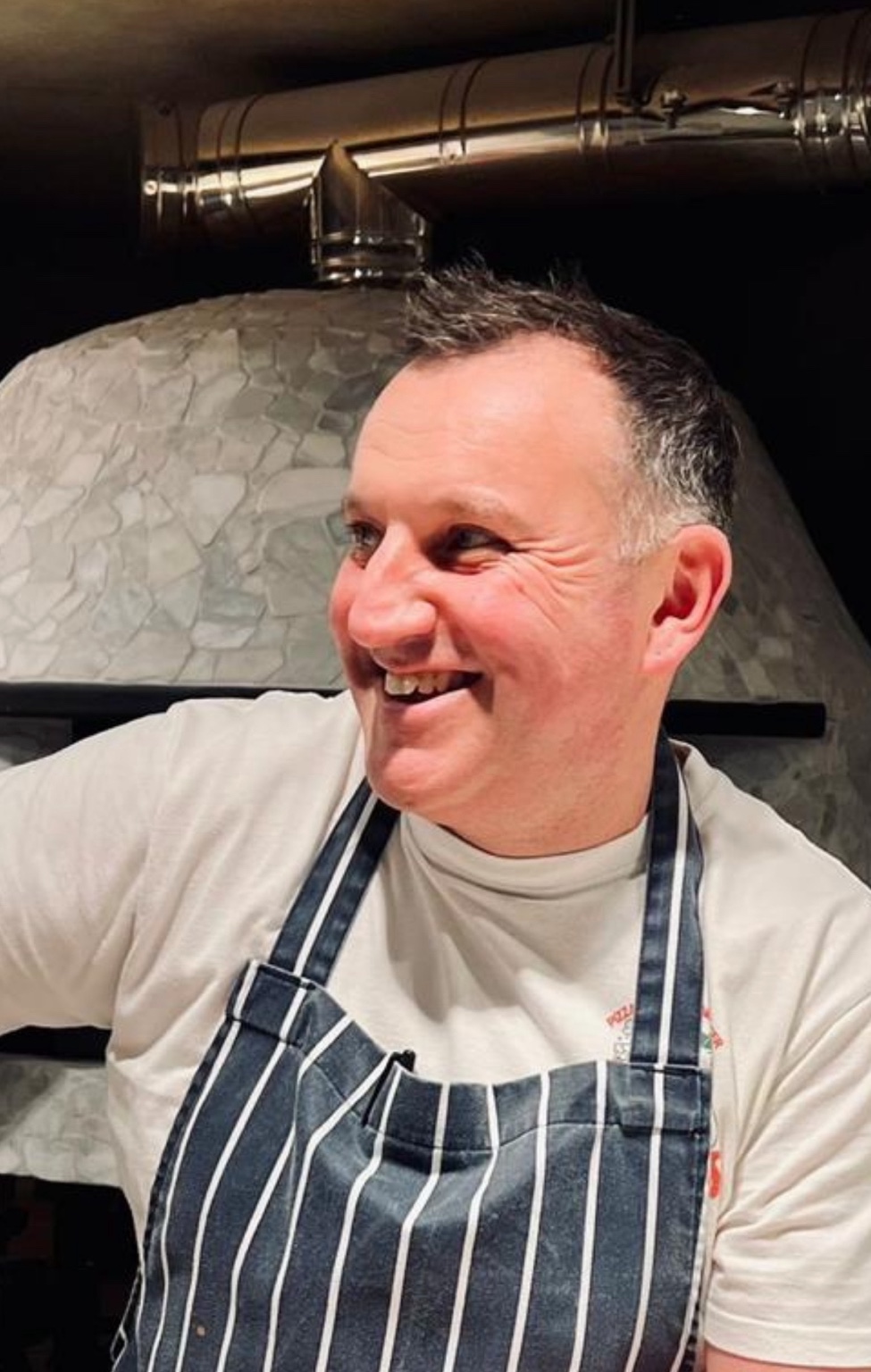 Mark Rush in front of a pizza oven